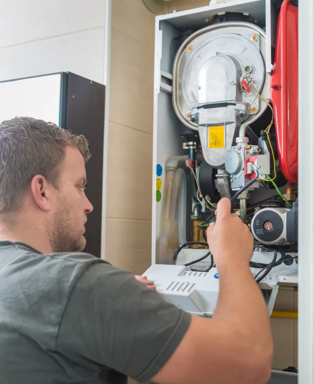 Technician inspecting a residential furnace heating system